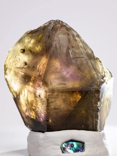 Backlit tricolored Skeletal Elestial quartz showing golden glow and purple internal flashes